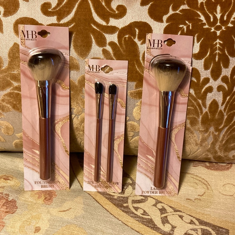 Set of four “Must Have Beauty” makeup brushes with matte rose gold handles.